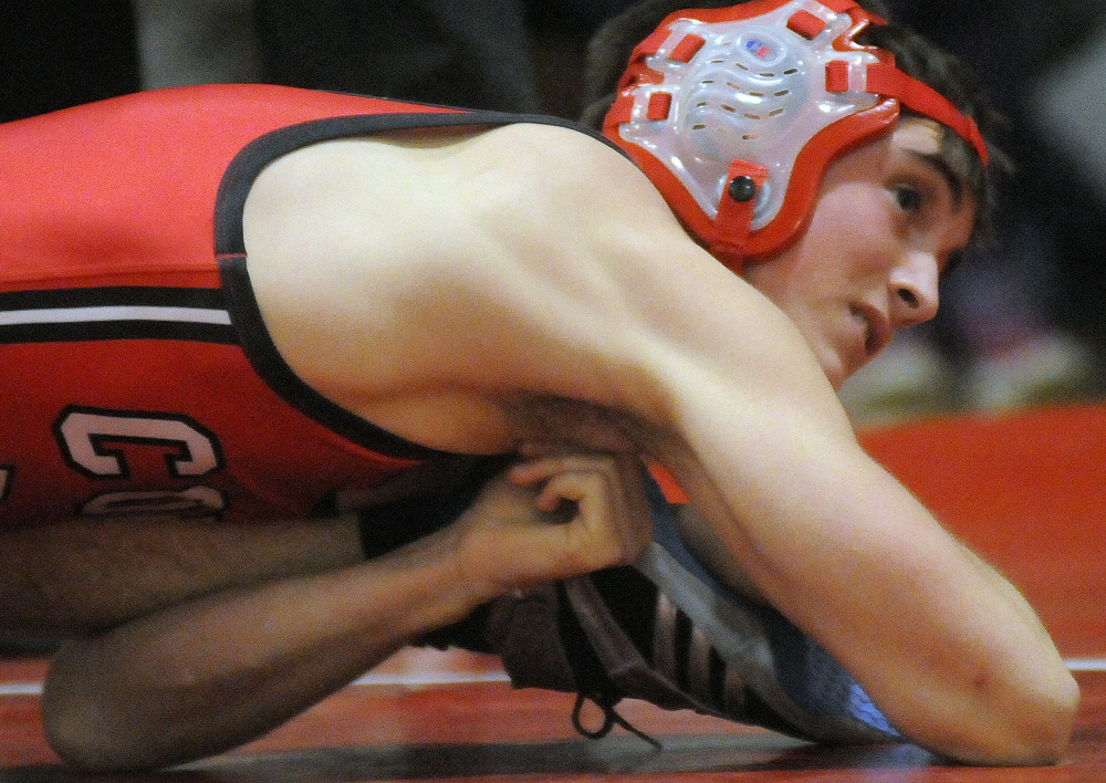 Cony sophomore Jakob Arbour holds down Oxford Hills wrestler Jason Perfect during a match Wednesday night in Augusta.