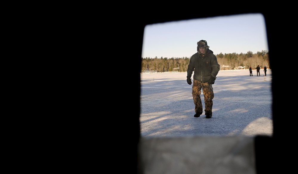 Josh Zayac runs to his ice shelter Monday to collect bait while fishing on Cochnewagon Lake in Monmouth. The Cony High School graduate and Washington state resident said he thinks conditions are safe for activities on lake ice.