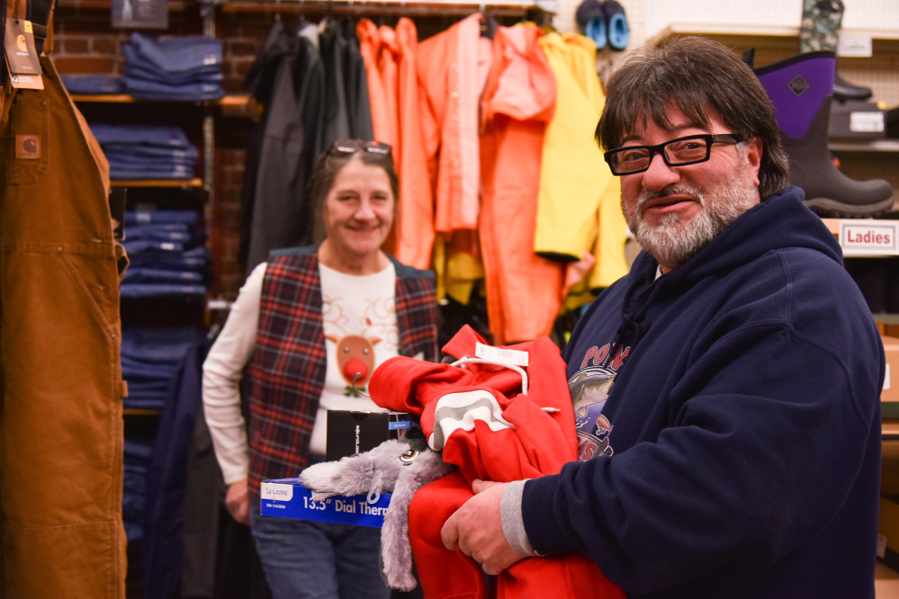 Dominick Pono, right, of Bath, gets some assistance from longtime Renys employee Mary Lewis, of Whitfield on Saturday in Gardiner.