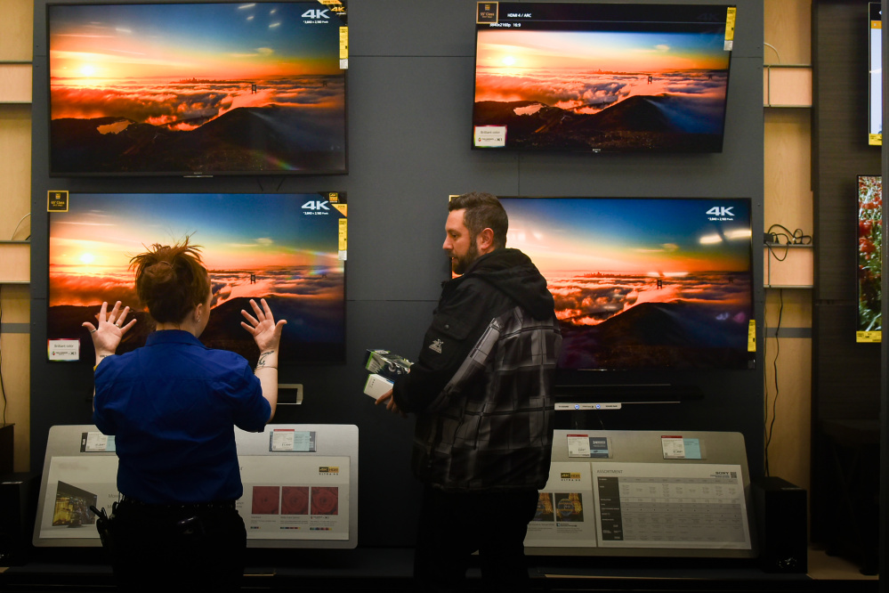 Sam Boynton, right, of Augusta consults with Best Buy employee Jennifer Hewey at the Best Buy store in Augusta on Saturday as shoppers picked up last minute gifts.