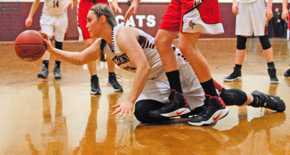 After diving to control a loose ball, Richmond's Sydney Tilton passes to a teammate during a game Friday at Richmond High School.