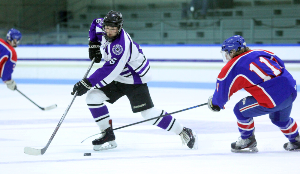 Photo by Jeff Pouland 
 Waterville Senior High School captain Andrew Roderique skates the puck around Messalonskee High School's Dustin Brown during a game earlier this season at Colby Colllege.