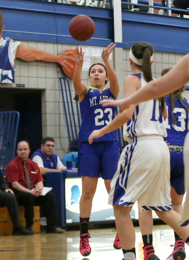 Mt. Abram's Summer Ross hits a 3-pointer in front of Madison defender Emily Edgerly during a game Tuesday night in Madison.