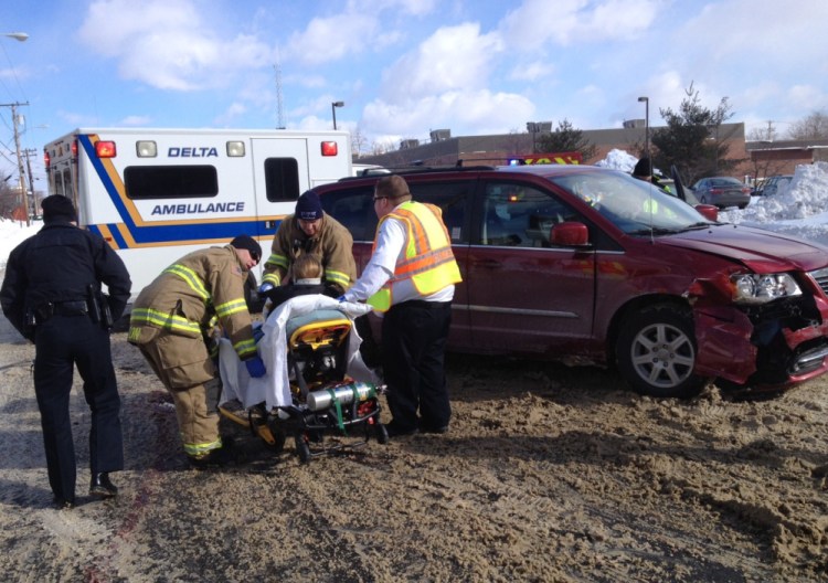 Melissa Finley, of China, is taken by stretcher to a waiting ambulance after a car crash Friday morning on College Avenue in Waterville.