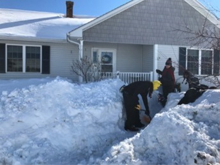 From left, Jade Crimmins, 13, Paige Spears, 14, and Werkay Bensen, 13, clear a walkway to the side of a condominium Friday at Heartland Estates in Winslow.