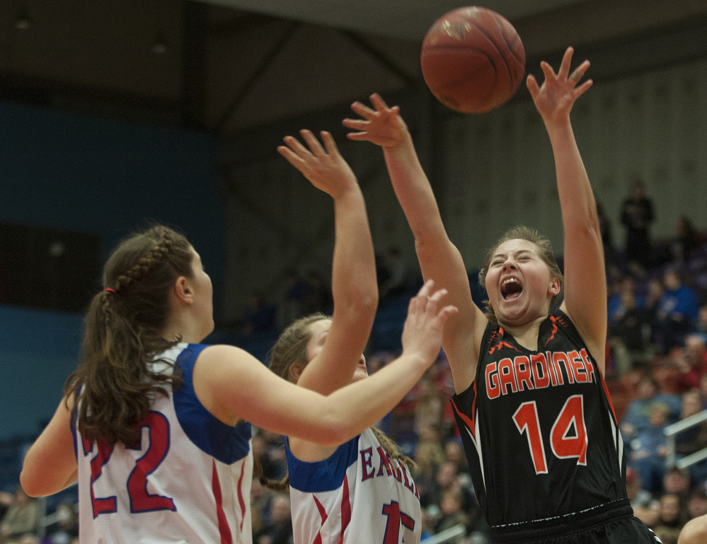 Gardiner's Logan Granholm throws up a shot as Messalonskee's Makayla Wilson and McKenna Brodeur defend during a Class A North quarterfinal game Friday at the Augusta Civic Center.