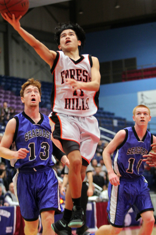 Forest Hills junior Kenn Vito Cruz splits Seacoast Christian defenders Sky Archer, left and Jesse Towne, right, during the first half of a Class D South boys quarterfinal in Augusta on Monday. Forest Hills lost 70-55.