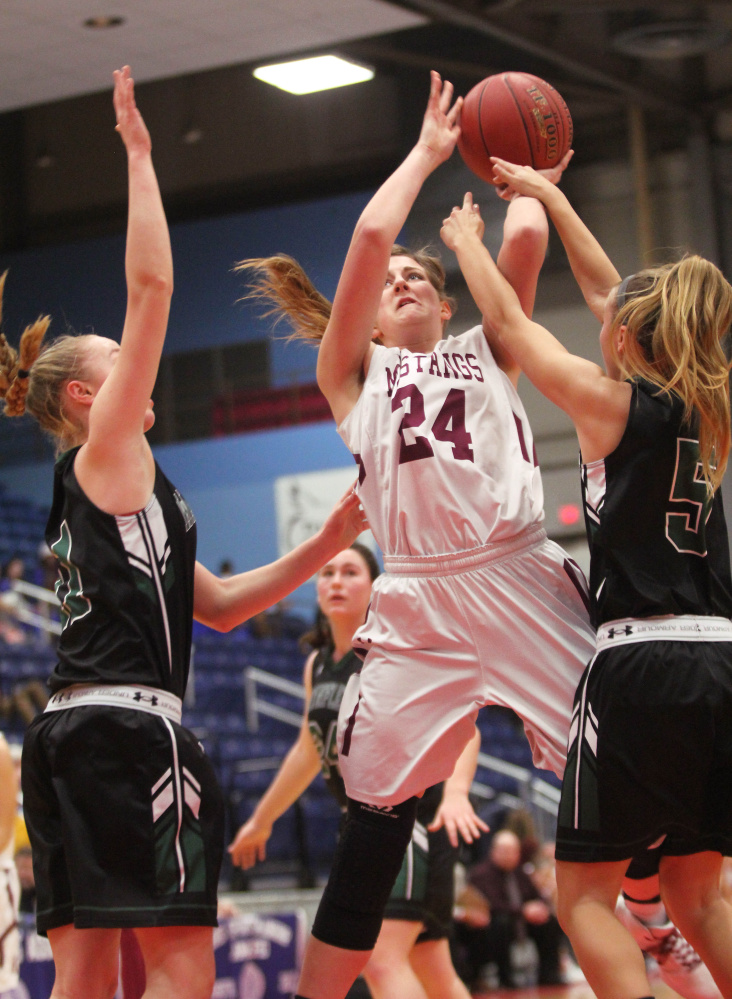 Monmouth Academy's Kaeti Butterfield puts up a shot over Waynflete's Lydia Giguere, left, and Isabel Burdick, right, during the first half a Class C South girls quarterfinal in Augusta on Monday. Monmouth won 45-40.