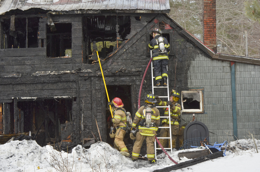 Firefighters make sure the fire at 17 Mt. Pisgah Road in Monmouth is extinguished after it flared up following an overnight fire.