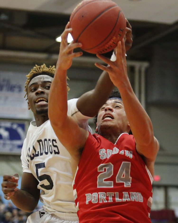 Portland's Pedro Fonseca, left, and Ansel Stilley of South Portland battle for a rebound in Saturday's state championship game. The game, played in Augusta, drew a fraction of the crowd that turned out for last year's title game in Portland between the same teams. 