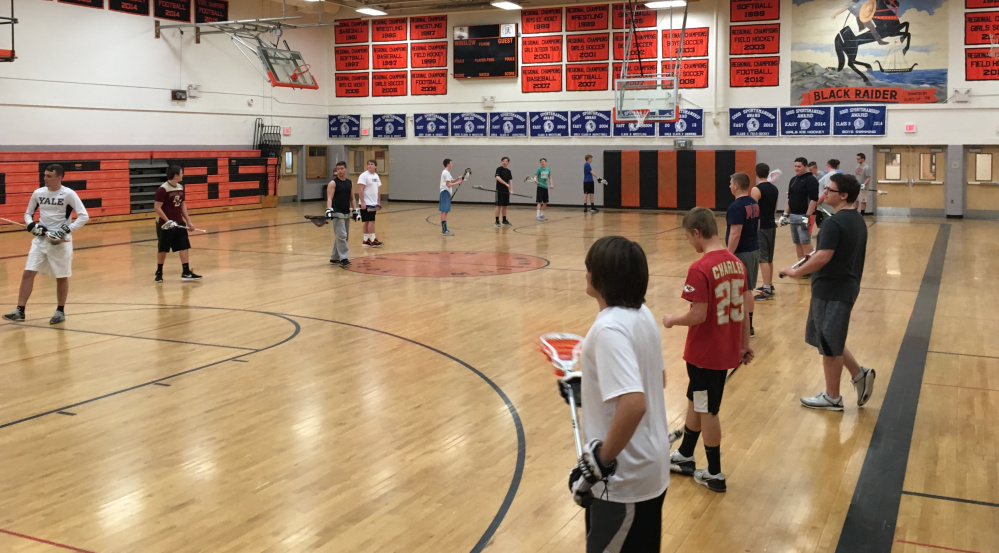 Members of the Winslow boys lacrosse team practice Monday inside the high school gymnasium.