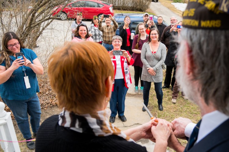 Martha St. Pierre, center left, Betsy Ann Ross House of Hope founder, is joined by board member Charles McGillicuddy in cutting a ribbonl at an April open house at a new shelter that will house up to eight homeless females veterans. Watching are representatives of state and local veteran organizations.