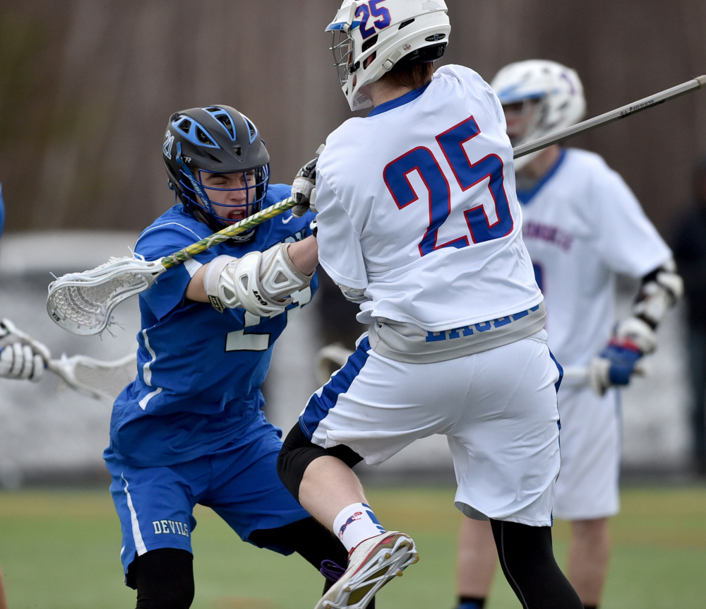 Messalonskee's Trevor McCray (25) battles with Lewiston's Ryan McCarthy during a game Thursday at Thomas College in Waterville.