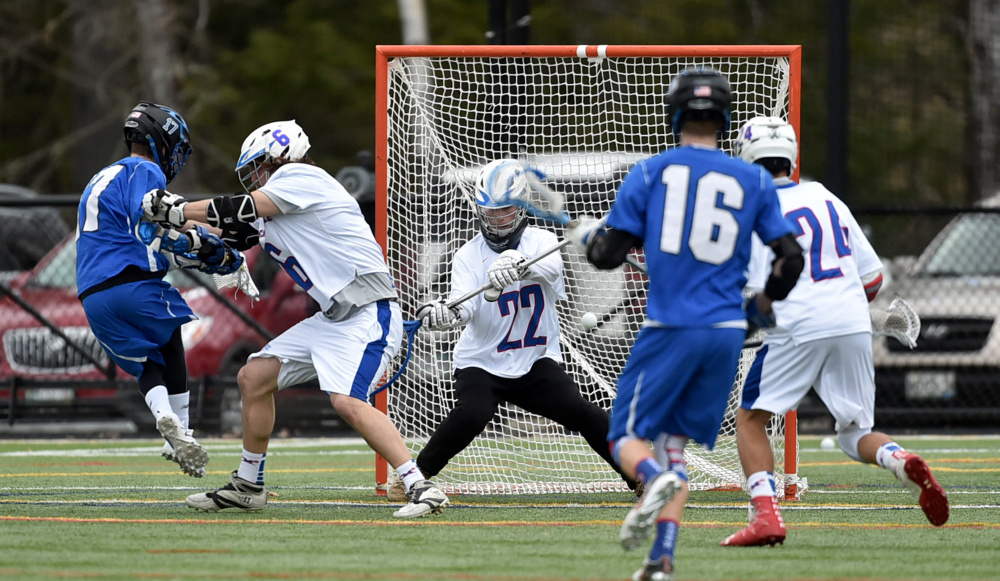 Messalonskee goalie Dawson Charles (22) makes a save on a shot by Lewiston's C.J. Reardon, far left, who is hit by Messalonskee's Dylan Gagne on Thursday at Thomas College in Waterville.