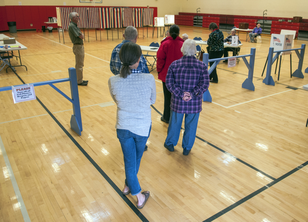 Staff photo by Joe Phelan
Voters wait in line at 7:59 a.m. Friday for polls to open at 8 a.m. for the bond vote in the Hall-Dale Elementary School gymnasium in Hallowell.