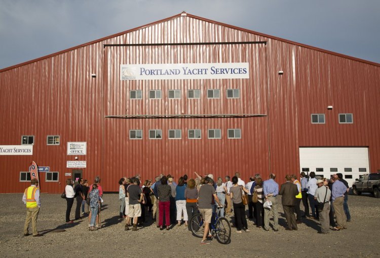 Portland Planning Board members and others get a tour Thursday evening on the waterfront site where a proposed cold storage facility would be built. The nearby Portland Yacht Services building was used to compare what the height of the proposed building might look like.