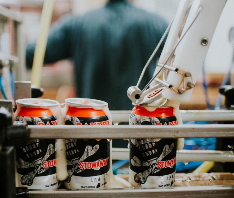 Cans of Baxter's Stowaway IPA are topped off at the company's Lewiston brewery.