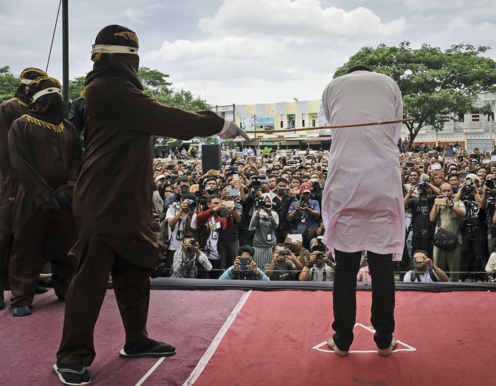 A team of five hooded Shariah law enforcers took turns caning two men for consensual gay sex in Banda Aceh, Indonesia, Tuesday. Each man was caned 83 times.