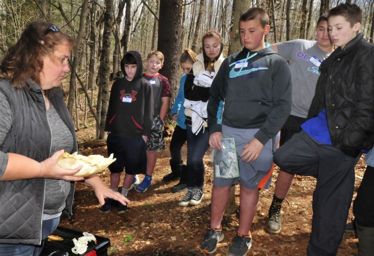 Missy Brandt asks Skowhegan Middle School students questions about the different characteristics of wildlife skulls at one of the stations in the woods behind the Marti Stevens Learning Center in Skowhegan during a forest field day on Wednesday.