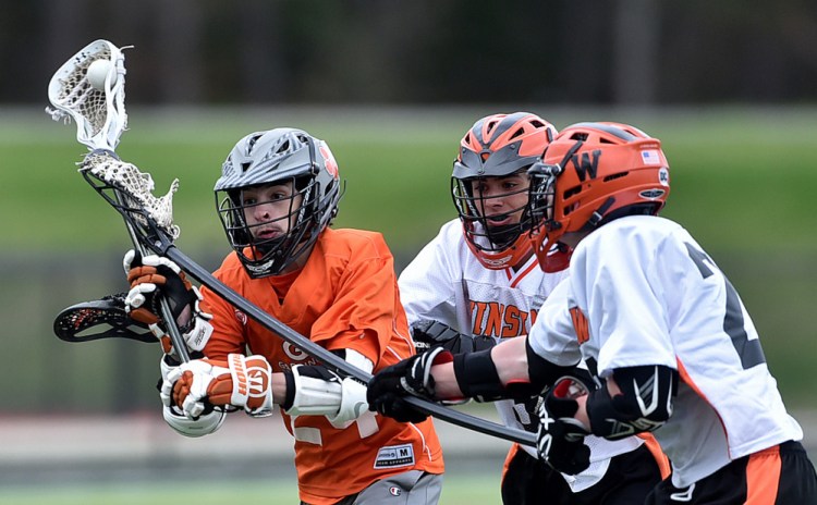 Gardiner Area High School's Bradley Phillis, left, takes a shot as he is defended by Winslow High School's Garrett Pooler, right, at Thomas College in Waterville on Tuesday.