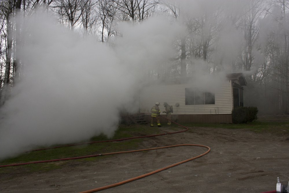 A mobile home at 905 Smithfield Road in Belgrade is barely visible Wednesday through the smoke.