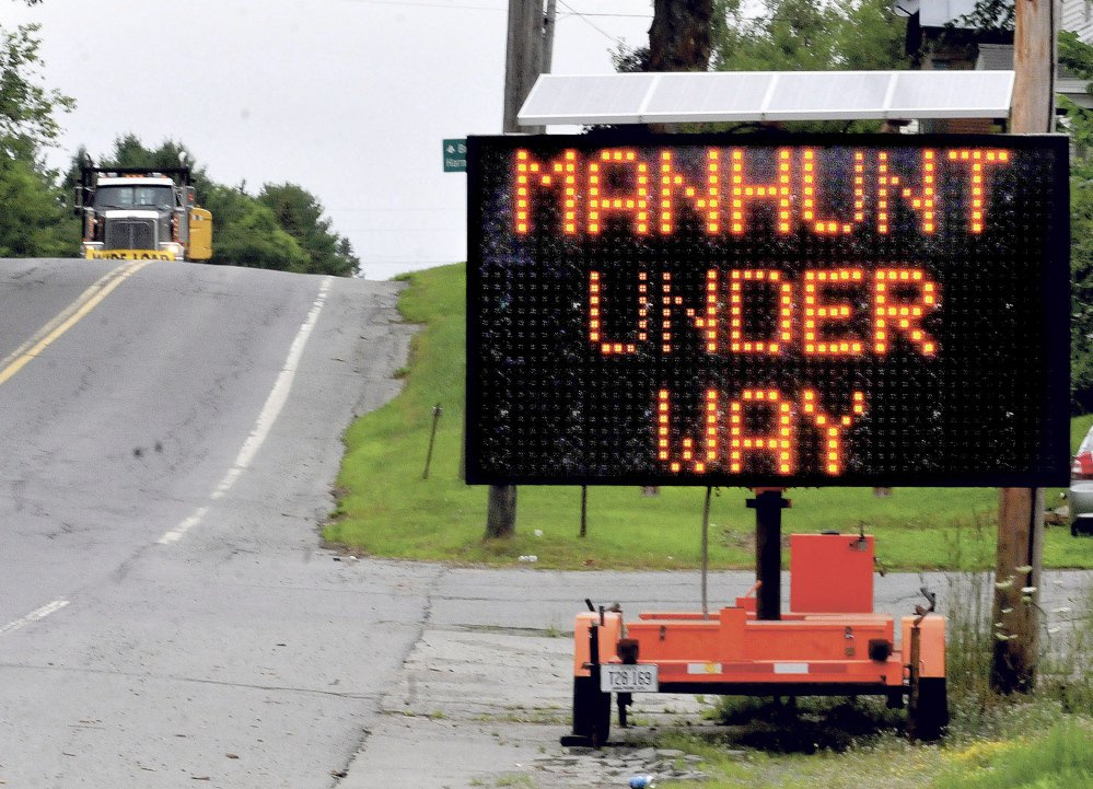 A trucker comes down Route 150 into the town of Athens in July 2015 near a large sign warning people about the hunt for murder suspect Robert Burton. Burton was on the run for more than nine weeks before he turned himself in at the Piscataquis County Sheriff's Office in August.