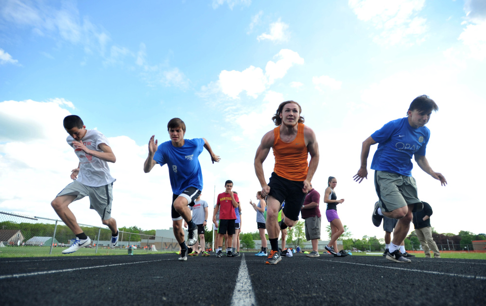 Winslow's Jacob Bisson, left, Spencer Miranda, left center, Ryan Fredette, right center, and Jake Warn work out during track practice Wednesday at Winslow.