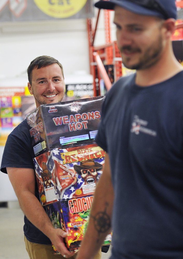 Ben Wittman of Windham, left, leaves Pyro City Fireworks in Windham with an armful of fireworks on Friday.