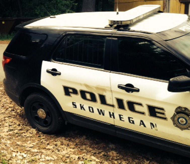 A Skowhegan police cruiser stands parked on Prescelly Drive in Skowhegan near the spot where a body was found Saturday in the woods.