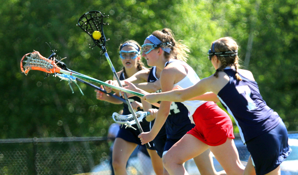 Messalonskee's Kaitlyn Smith moves the ball up the field past Portland  midfielder Caitriona Moran during the first half of a Class A North girls lacrosse quarterfinal Wednesday at Thomas College.