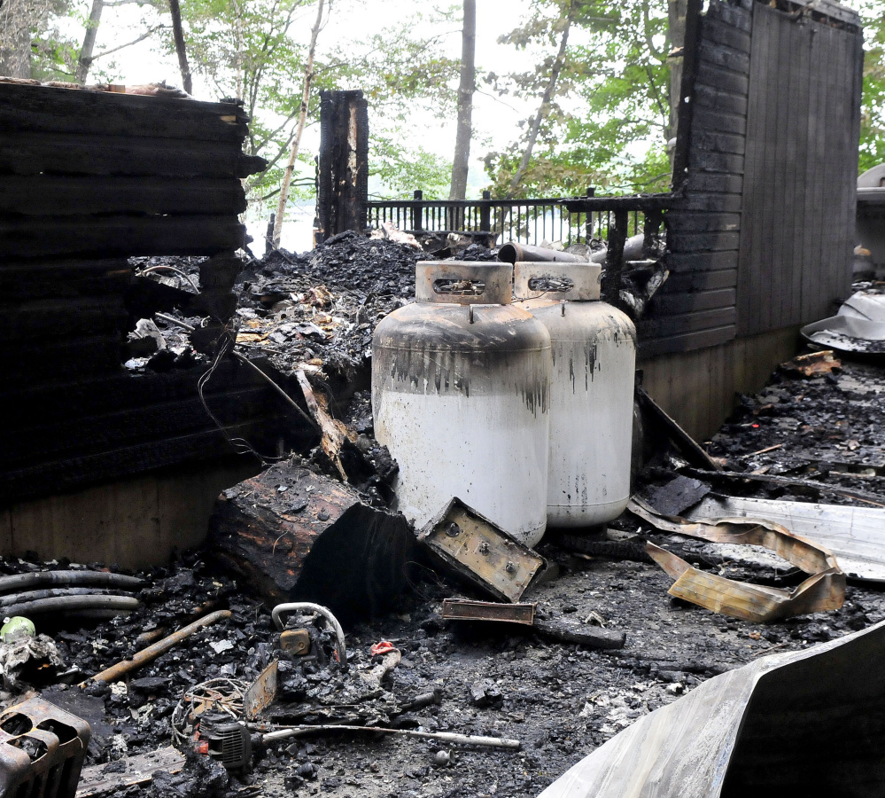 Two large propane tanks were scorched but did not explode at this cottage on Brickett Point Road on East Pond in Oakland. The home was destroyed by fire on Saturday.