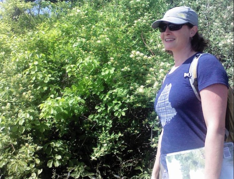 Kelly Corbin stands near honeysuckle at Fort Williams.