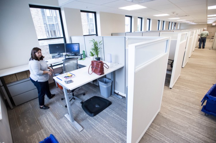 Tam Huynh, assistant director of prospect research and analysis for Colby College, settles in to her new work space on the second floor of the Hains building in Waterville on Friday.