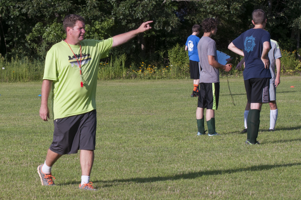 Phil Hubbard gives instructions to the Temple Academy boys soccer team during practice on Monday at Thomas College in Waterville.