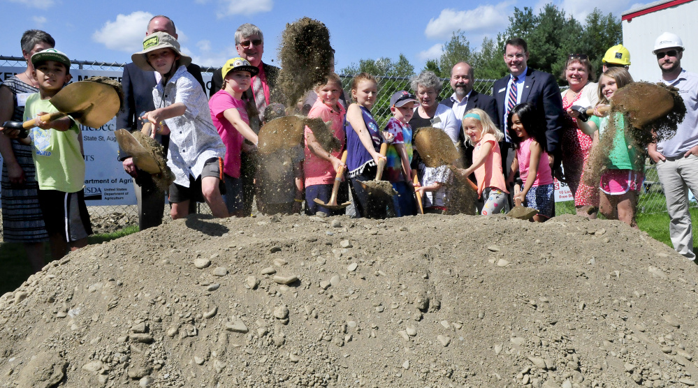 Students who attend Kennebec Montessori School joined school, local and federal officials in pitching in some dirt during a groundbreaking ceremony for the USDA financed expansion project at the Fairfield school Thursday.