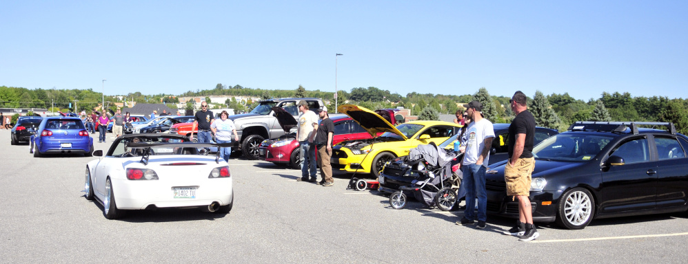 Cars drive down the center aisle and park at the end during a Hurricane Harvey fundraising car show Saturday at the Augusta Civic Center.