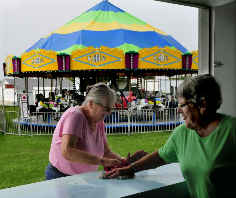 Pam Nuite, left, and Shirley Pierce, of the Clinton Evening Extension organization, clean off counter space Tuesday at the club's dough-boy kiosk for the upcoming 2017 Clinton Lions Agricultural Fair. The fair runs Thursday though Sunday.