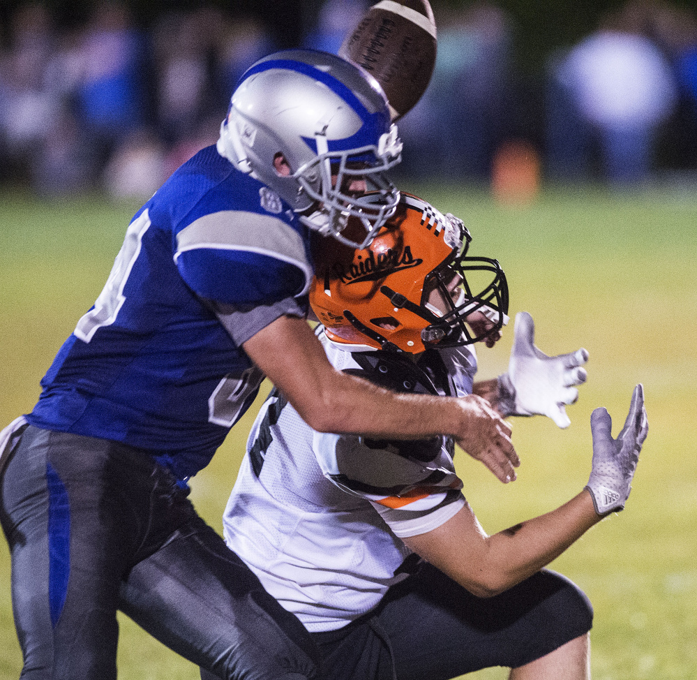 Winslow receiver Hunter Campbell, right, bobbles a pass as Lawrence defender Jimmy Dixon defends during a game Friday night at Keyes Field in Fairfield.