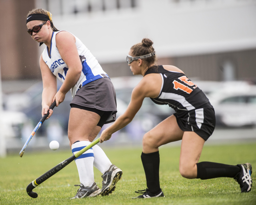 Lawrence High School's Hunter Mercier (14) passes the ball as she is defended by Winslow High School's Anna Petrovic (15) in Fairfield on Saturday.