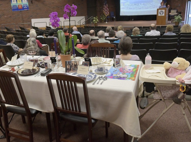 "An Empty Place at the Table," arranged with utensils and possessions of homicide victims, is displayed Monday during the Maine Day of Remembrance for Murder Victims in Augusta.