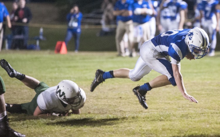 Madison's Evan Bess, right, gets tripped up by Winthrop/Monmouth defender Carson Camick during a recent Class D South game at Rudman Field in Madison. The Bulldogs play Old Orchard Beach on Friday