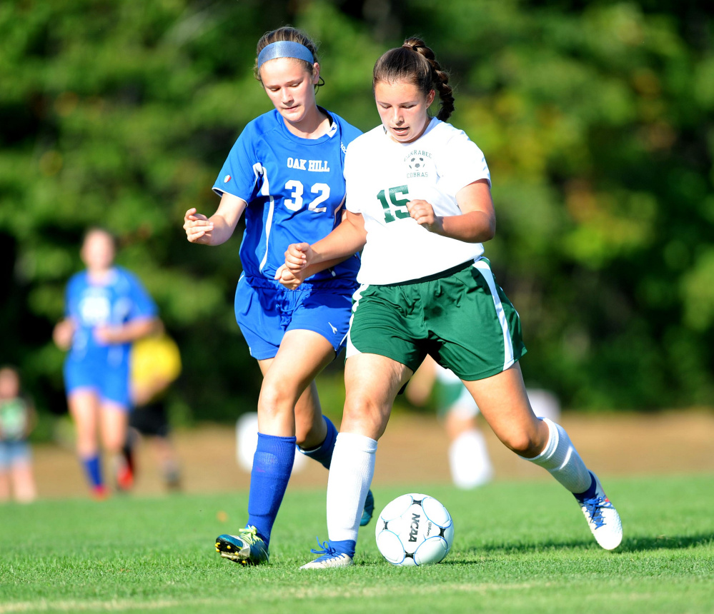 Carrabec High School's Annika Carey, right, battles for the ball with Oak Hill High School's Cassie Gauthier. left, in North Anson on Wednesday.