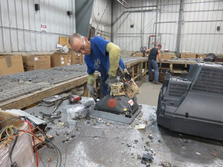 Chris Waterhouse takes apart a computer monitor at eWaste Recycling Solutions in Auburn. 
  
 Photo courtesy of eWaste Recyling Solutions.