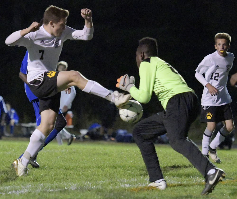 Maranacook's Mitchell Root fires a shot that is blocked by Lewiston goalie  Dido Lumu during a Kennebec Valley Athletic Conference game Tuesday  in Readfield.