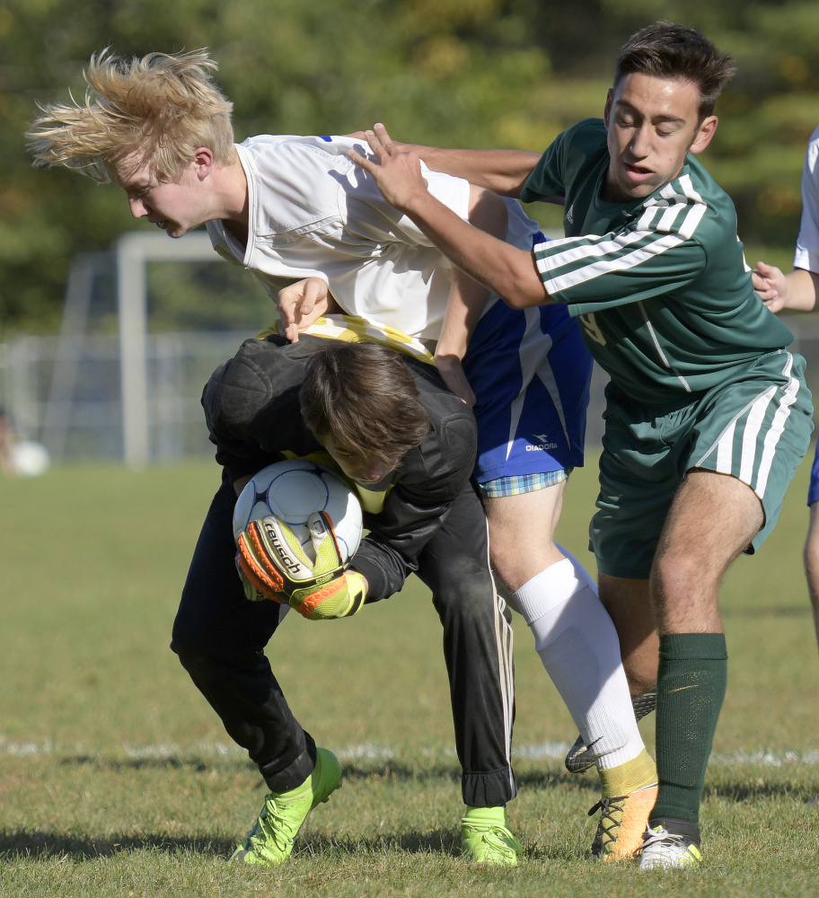 Oak Hill High School's Max Hall, center, and keeper Cole Whitten collide with Winthrop's Jared McLaughlin during a Mountain Valley Conference game Wednesday afternoon in Wales.