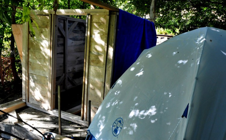 Vaughn Orchard, who is homeless and was living in a tent near Pan Am Railways train tracks in Waterville, has been charged with criminal trespass. Recently a wood frame building has been partially erected beside his tent. The train tracks can be seen 50 feet away.