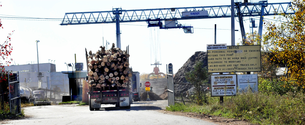 Pulp trucks loaded with wood enter an entrance to SAPPI mill in Skowhegan a short time after a fire was reported at the mill on Thursday.