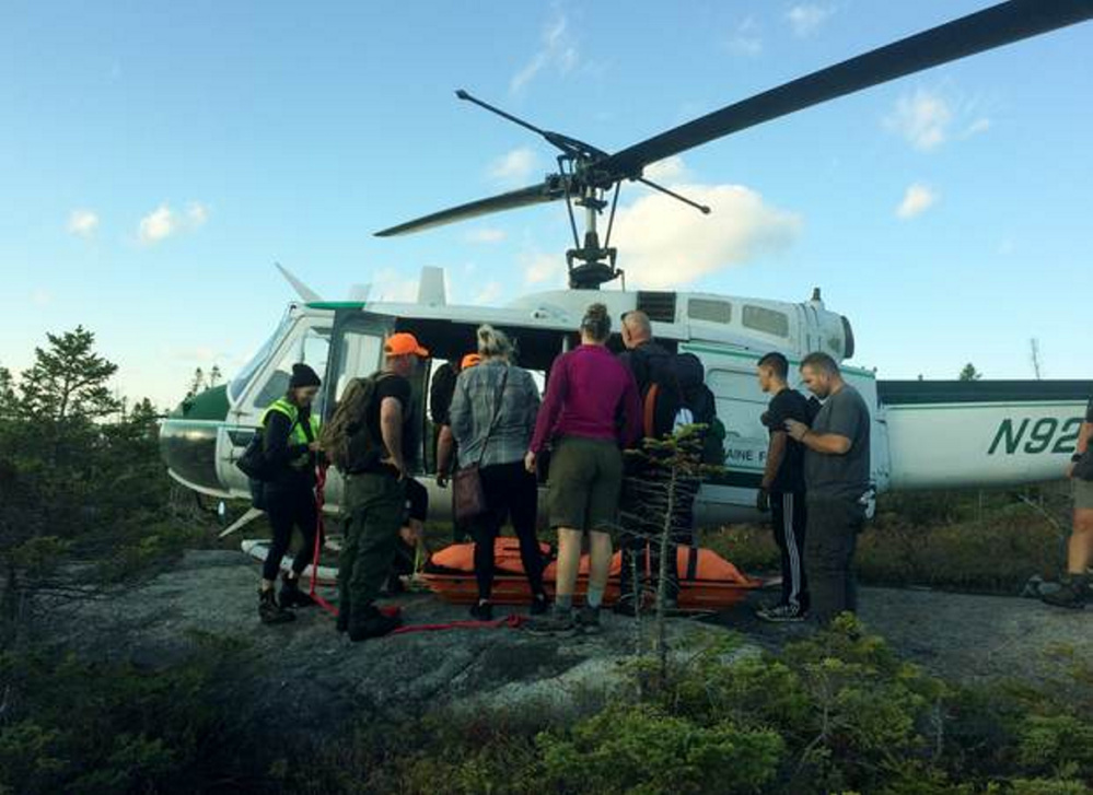 Rescuers carry Kelsey Lampher, of Phoenix, Ariz., to a helicopter after she injured her ankle Tuesday while hiking the Appalachian Trail on Bemis Mountain in Township D in northern Franklin County.