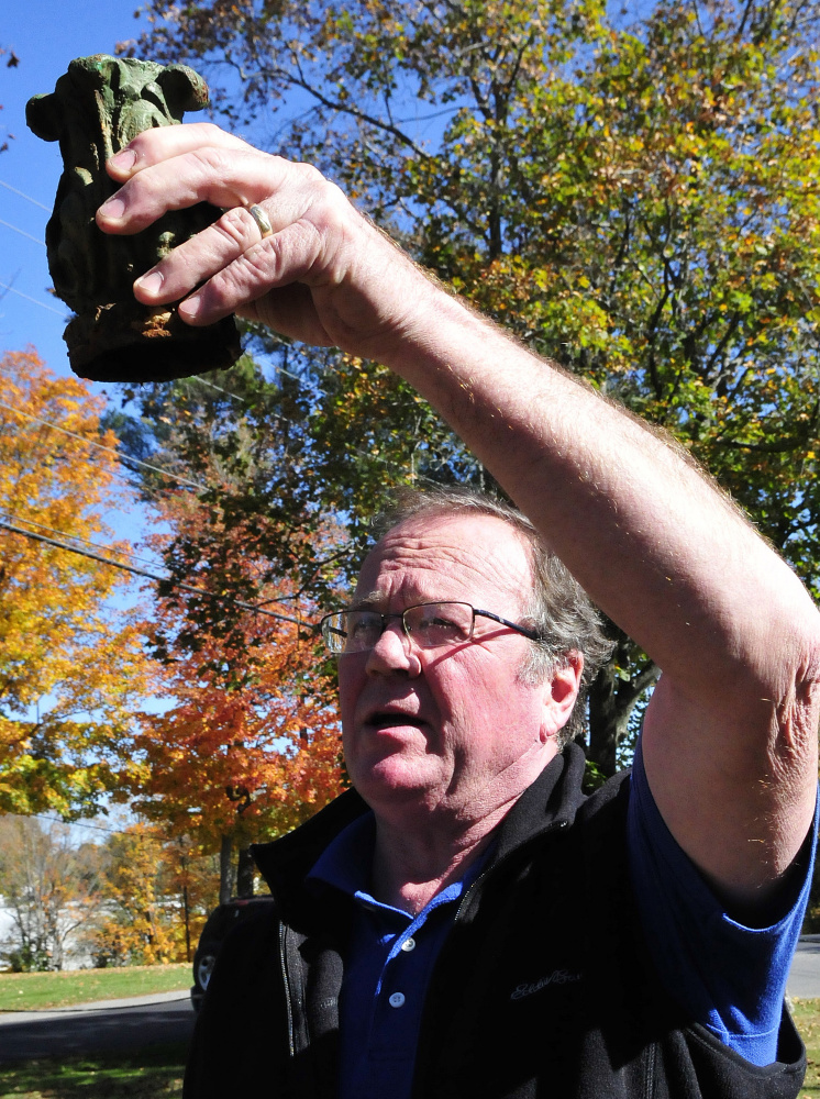 Skowhegan Road Commissioner Greg Dore holds the top piece of the century-old fountain at Main Street Commons off Main Street in Skowhegan on Thursday. The fountain had been vandalized recently.