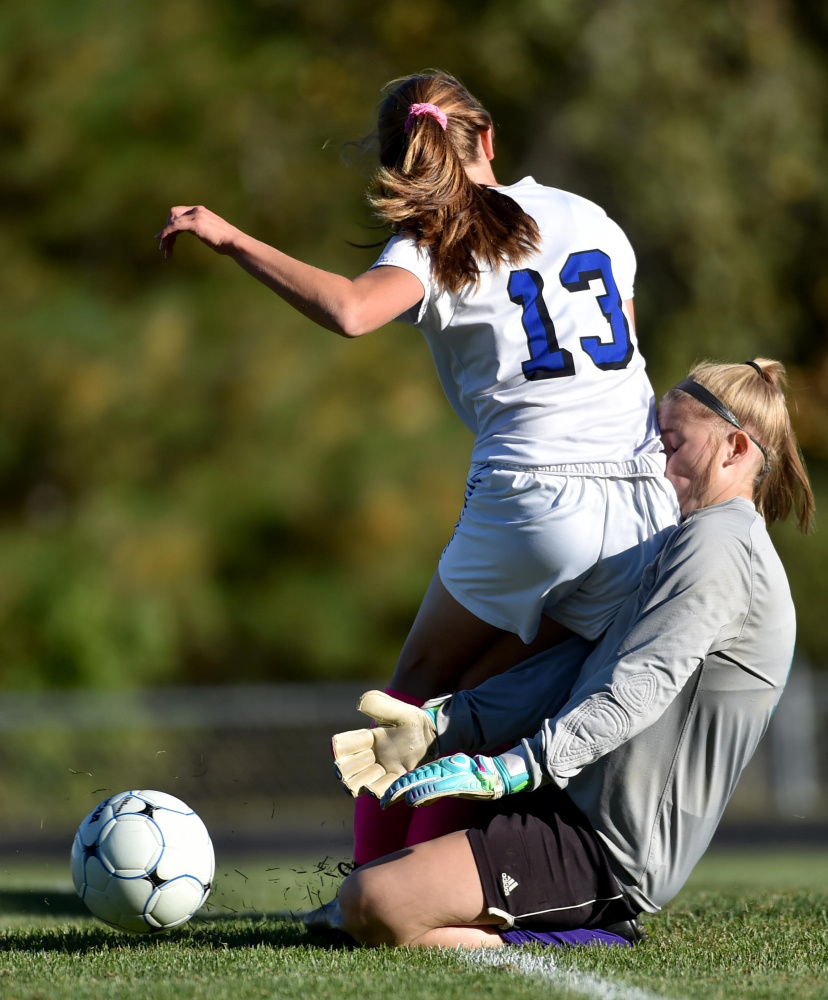 Erskine sophomore Morgan Presby (13) collides with Waterville goalie Aly Drew during a Class B North game Friday in South China.